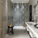 Bagno con rivestimento a listelli verticali nei toni del grigio e lavabo sospeso