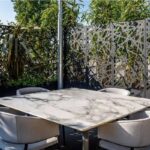 Pannelli divisori traforati su una terrazza con tavolo e sedute