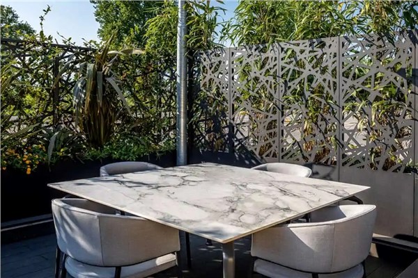 Pannelli divisori traforati su una terrazza con tavolo e sedute