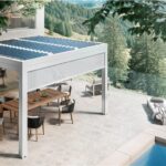 Pergola bioclimatica con pannelli fotovoltaici sopra un patio con piscina