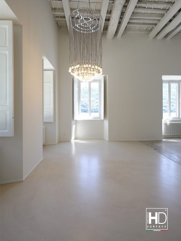 Sala con volte in muratura, pavimento continuo chiaro e lampadario a gocce