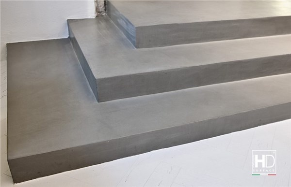 Scala con rivestimento continuo in resina grigia e gradini a sbalzo