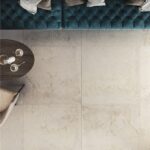 Pavimento in gres effetto marmo bianco con divano capitonne e tavolino