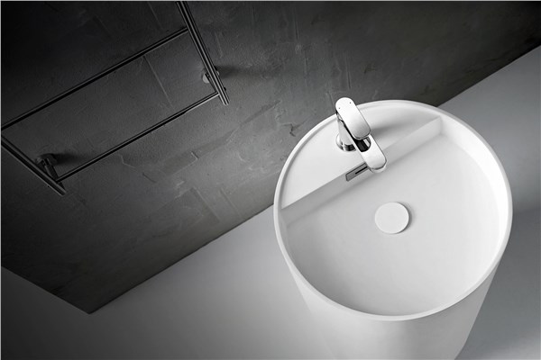 Lavabo tondo bianco su pavimento scuro con gradino e miscelatore