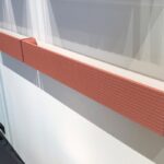 Termoarredo orizzontale arancione montato sotto una finestra