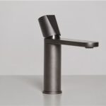 Miscelatore da lavabo in finitura scura su fondo grigio