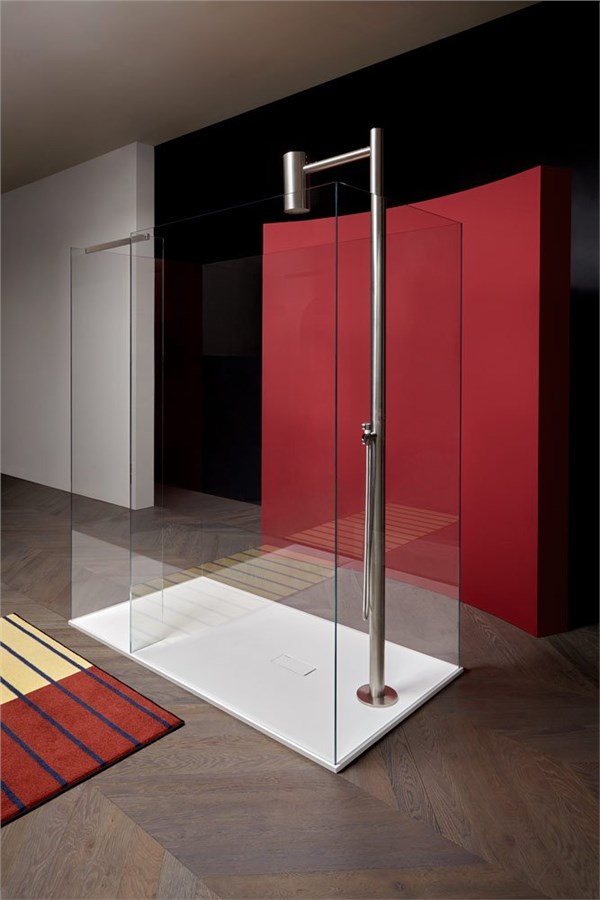 Doccia walk-in con parete in cristallo e colonna doccia in un ambiente rosso