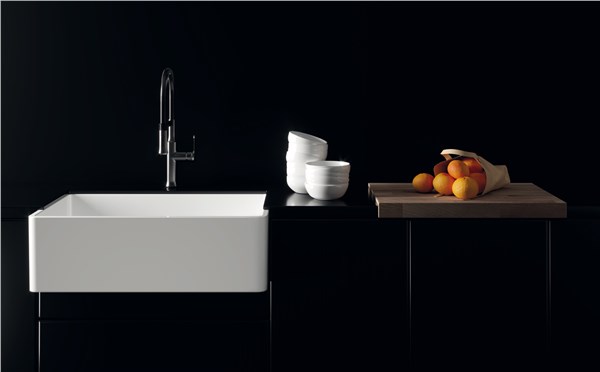 Lavabo bianco rettangolare su piano scuro con miscelatore e frutta