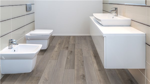 Bagno con sanitari sospesi bianchi, mobile e pavimento effetto legno