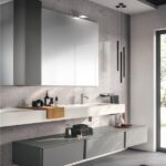 Bagno con mobile sospeso grigio, lavabo integrato e specchio contenitore