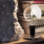 Lampada da tavolo con paralume e struttura metallica su una libreria