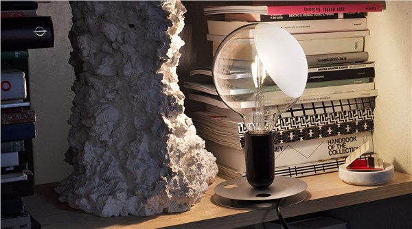 Lampada da tavolo con paralume e struttura metallica su una libreria