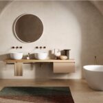 Bagno con volte ad arco, doppio lavabo d'appoggio e vasca freestanding