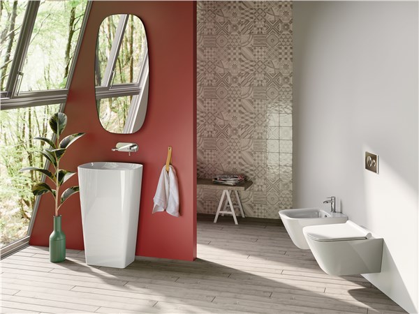 Bagno con parete rossa, lavabo freestanding bianco e sanitari sospesi