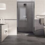 Bagno con pavimento in gres effetto pietra, doccia e vasca freestanding