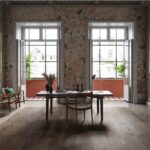 Sala da pranzo in un loft con pareti in pietra e pavimento in legno