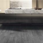 Cucina con isola effetto marmo e pavimento in parquet grigio scuro
