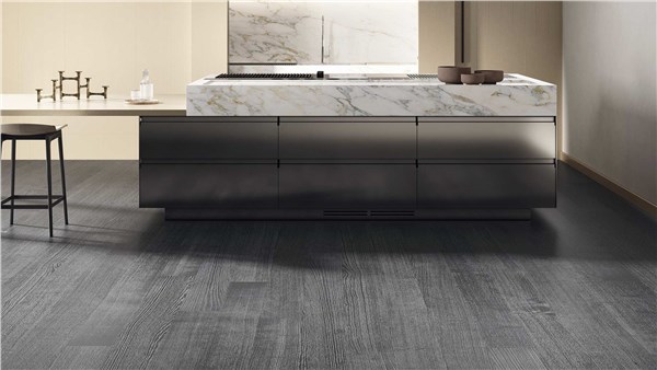 Cucina con isola effetto marmo e pavimento in parquet grigio scuro