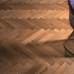Pavimento in parquet con posa a spina di pesce e sgabello metallico