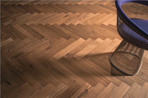 Pavimento in parquet con posa a spina di pesce e sgabello metallico