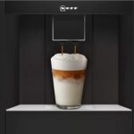 Macchina da caffè automatica da incasso con bicchiere di cappuccino