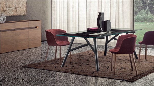 Tavolo da pranzo con piano scuro, sedie bordeaux e tappeto in un soggiorno