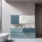 Bagno con mobile azzurro a cassettoni, lavabo integrato e vasca freestanding