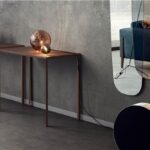 Due consolle sottili in metallo e legno lungo una parete effetto cemento