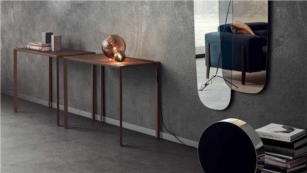 Due consolle sottili in metallo e legno lungo una parete effetto cemento