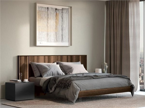 Camera da letto con letto matrimoniale, testata imbottita e quadro a parete