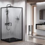 Box doccia angolare con profili neri accanto a un mobile bagno sospeso