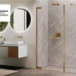 Bagno con box doccia dai profili dorati, doppio lavabo e rivestimento a spina