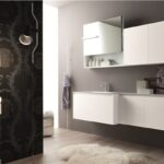 Mobile bagno bianco sospeso con pensili e parete decorata a motivi scuri