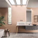 Bagno con parete rosa, lavabo su mensola e vasca freestanding