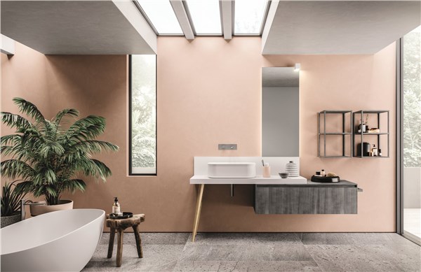 Bagno con parete rosa, lavabo su mensola e vasca freestanding