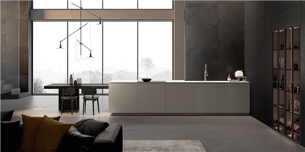 Cucina con isola dal profilo obliquo, vetrata e libreria a parete