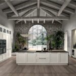 Cucina classica bianca con isola, colonne attrezzate e finestra ad arco