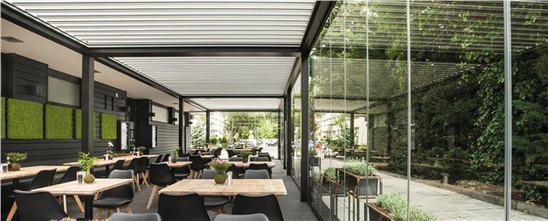 Pergola bioclimatica che copre la sala esterna di un ristorante con tavoli apparecchiati