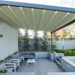 Pergola bioclimatica con lamelle e illuminazione integrata sopra un patio