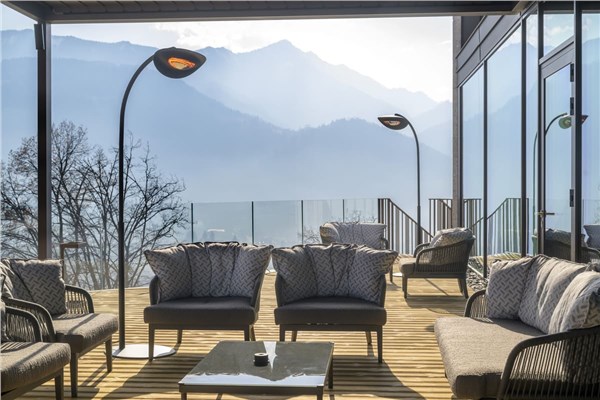 Terrazza panoramica con lampade riscaldanti sospese e salotto da esterno