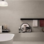 Bagno con rivestimento a rilievo fino a mezza altezza, vasca e doppio lavabo