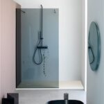 Doccia walk-in con parete in cristallo e piatto doccia filo pavimento