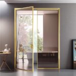 Porta a vetri con telaio dorato che separa un ambiente con vasca
