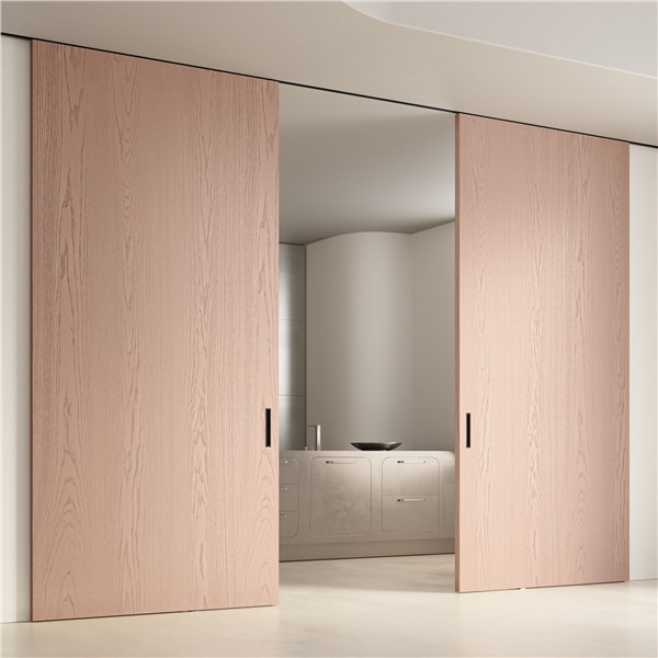 Due porte scorrevoli in legno chiaro a tutta altezza su una parete continua