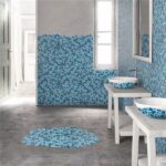Bagno con parete rivestita in mosaico azzurro, lavabo e tappeto coordinato
