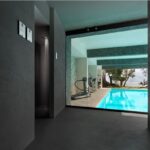 Ambiente con pareti in resina continua affacciato su una piscina interna