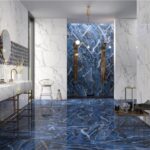 Bagno con pavimento in gres effetto marmo blu e pareti effetto marmo bianco