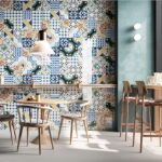 Locale con parete rivestita in cementine decorate, tavoli e sgabelli