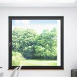 Camera con finestra a filo muro affacciata sul verde e parete effetto marmo