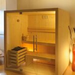 Sauna in legno con vetrata e panche illuminata dall'interno